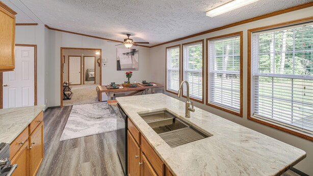 A kitchen with a large island, wooden cabinets, a built-in sink, and large windows with blinds. - 1 Mi to Geneva SP: Family Home w/ Game Room & Yard (Geneva)