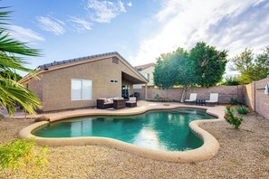 A backyard with a swimming pool, patio furniture, and a brick house. - Swim & Unwind: 'Wildrose Retreat' in Mesa! (Mesa)