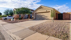 A residential house with a garage, driveway, and a white pickup truck parked in the driveway. - Swim & Unwind: 'Wildrose Retreat' in Mesa! (Mesa)