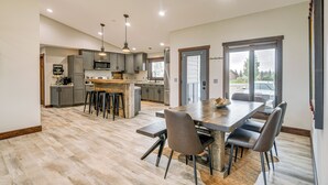 A spacious kitchen with a large island, modern appliances, and a dining area with a wooden table and chairs. - Pinedale Getaway Near Hiking, Skiing & Lakes! (Pinedale)