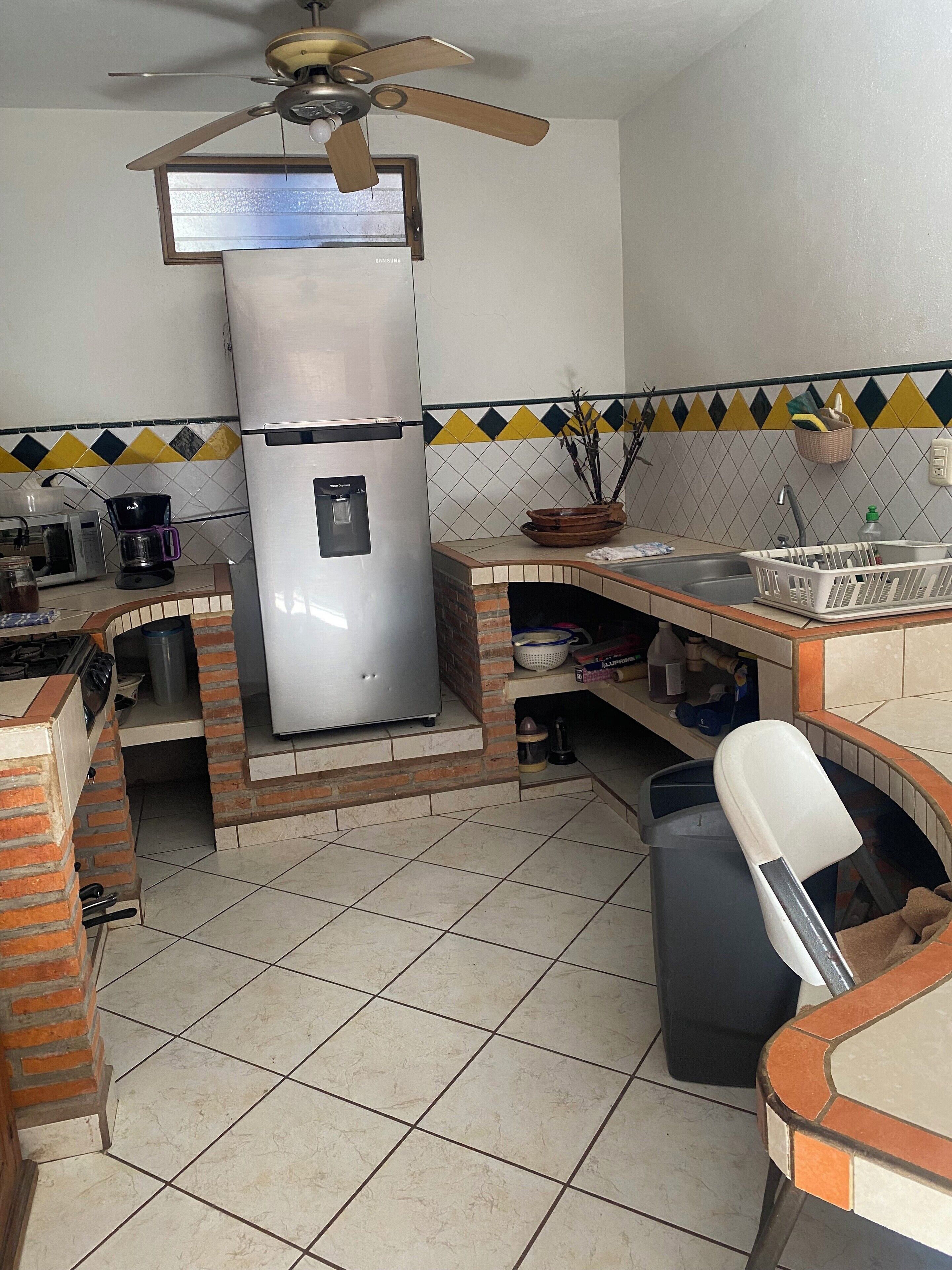 Een keuken met een roestvrijstalen koelkast, een koffiezetapparaat en een spoelbak.