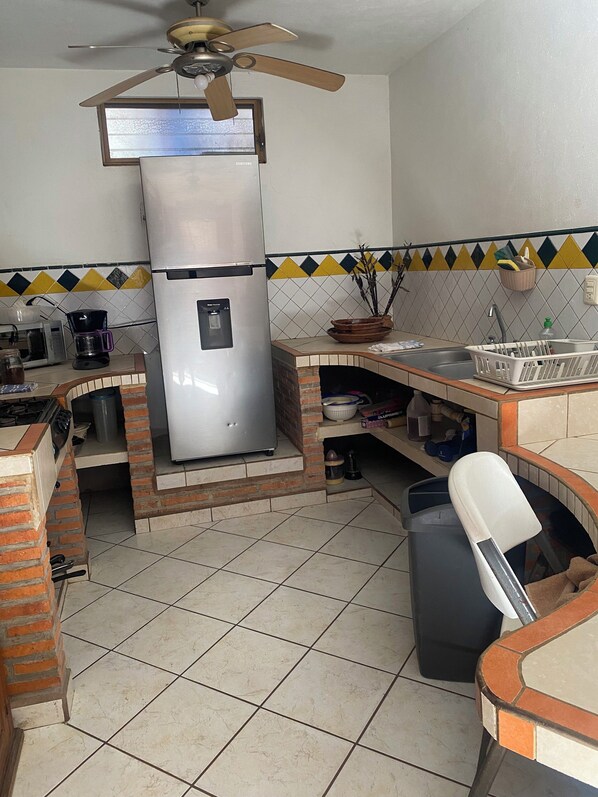 Una cocina con un refrigerador de acero inoxidable, una cafetera y un lavabo.