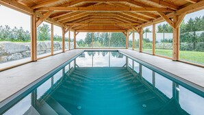 Ein Hallenbad mit Holz-Dachkonstruktion und großen Glaswänden.