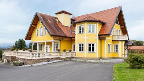 A large, yellow building with multiple windows and a red-tiled roof.