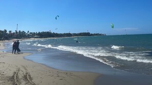A beach with clear skies and people engaging in water activities.