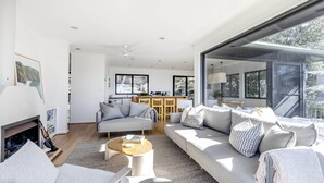 A modern living room with a sofa, coffee table, and fireplace. - Great Views, Walk To Beach and Bay In Bush Setting (KILLCARE)