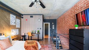 A modern bedroom with a bed, a desk, and a TV. - Obsidian City View, Sky Lounge, Sauna, RL Therapy (Charlotte)