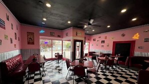 Een eetcafé met geruite vloeren, rode zitbanken en een klassiek Amerikaans interieur.