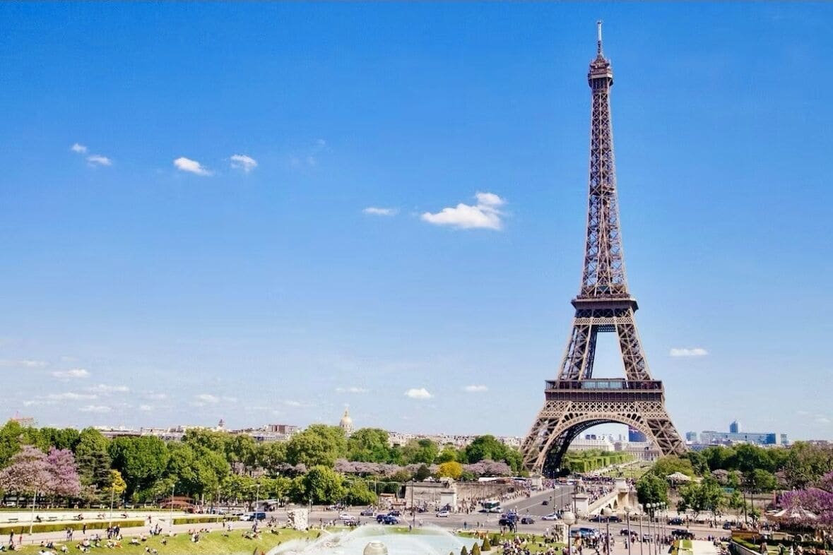 The Eiffel Tower in a park with open spaces and pathways.