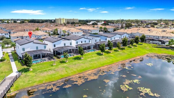 A residential area with modern houses, a swimming pool, and a pond.