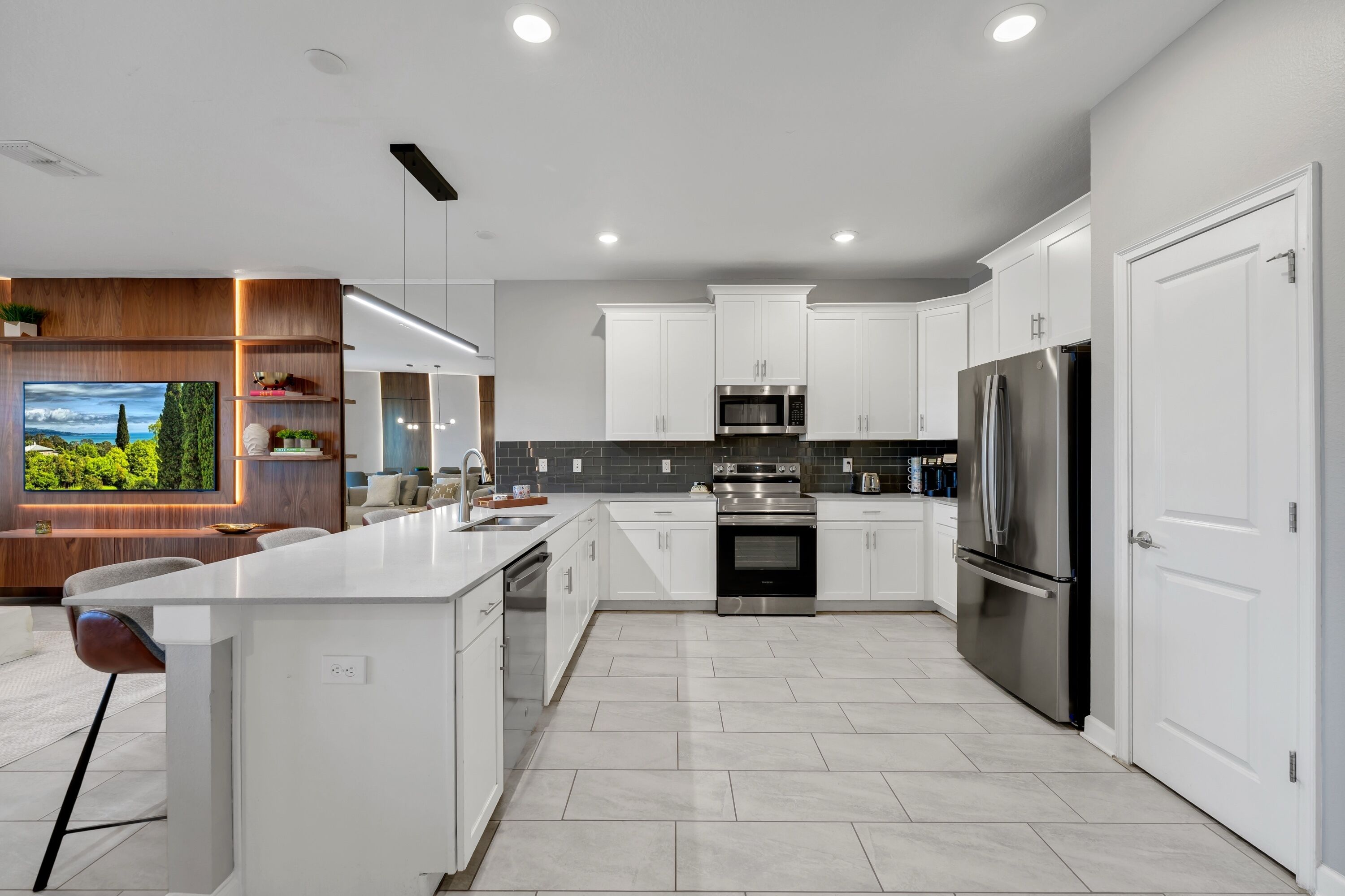 Una cocina moderna con armarios blancos, electrodomésticos de acero inoxidable y una isla grande.