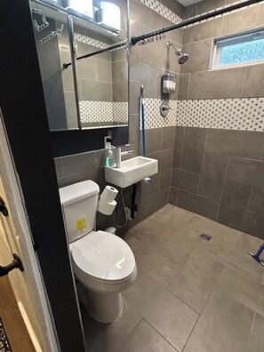 Ein Badezimmer mit Toilette, Waschbecken und Dusche.