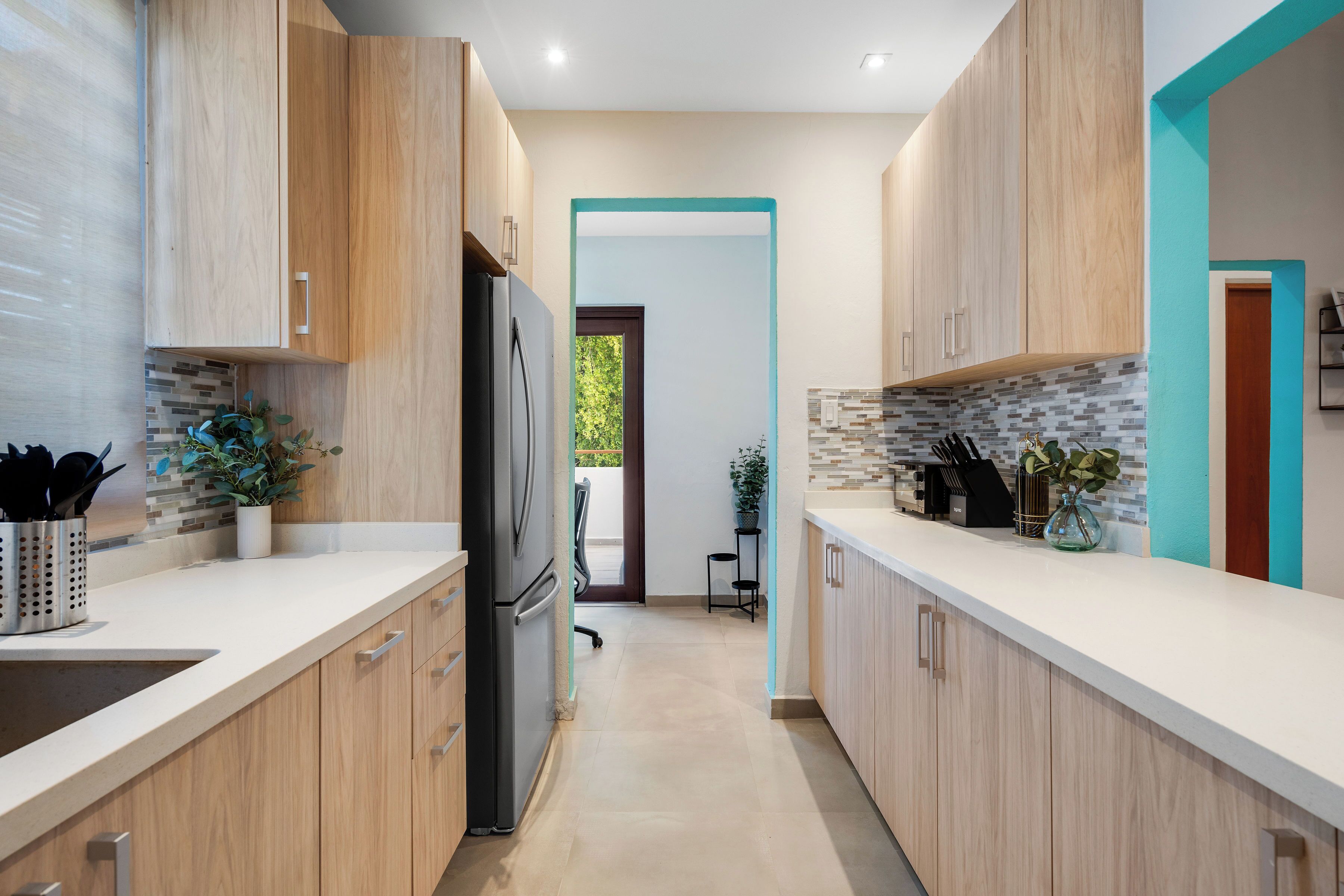 Una cocina moderna con armarios de madera, un refrigerador negro y un salpicadero de azulejos.
