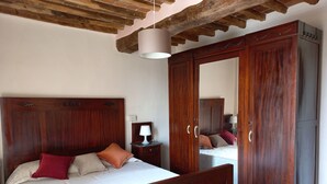 Une chambre à coucher avec un lit en bois, une armoire et une table de chevet avec une lampe.