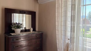 Une commode en bois avec un miroir et une plante en pot.