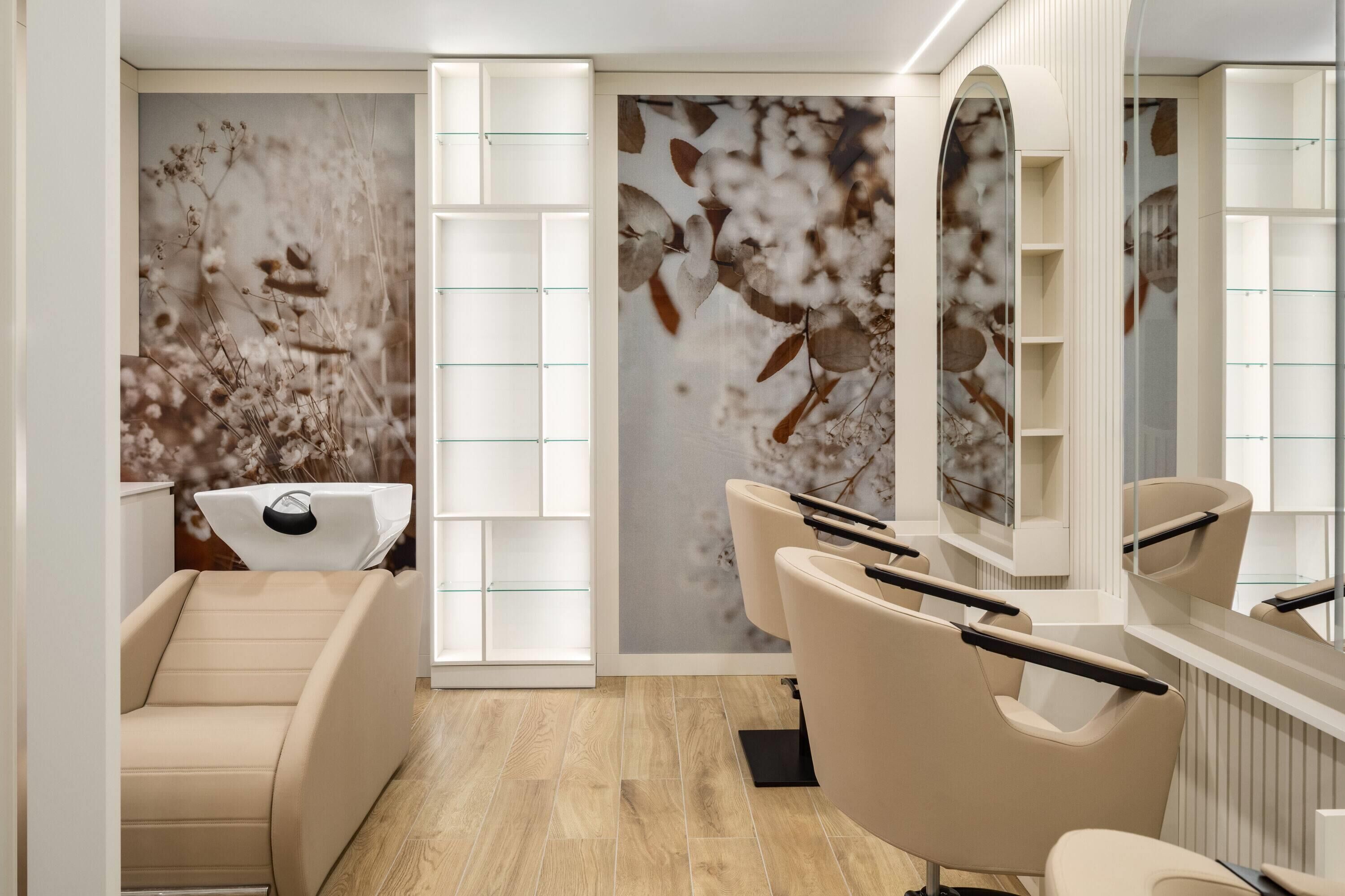 Un spa moderno con una silla de masaje, un espejo grande y una pared decorada con un mural floral.