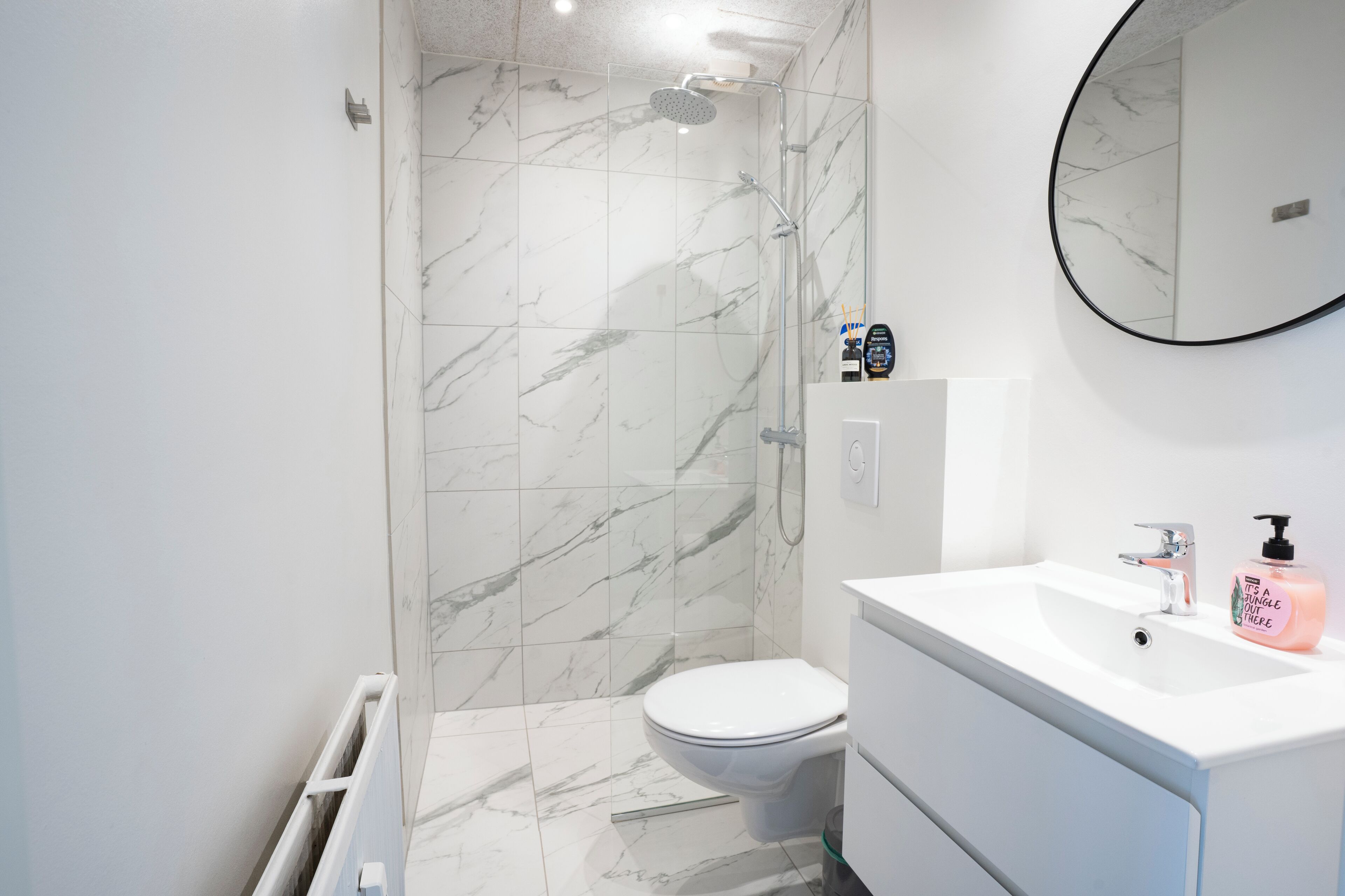Un baño moderno con inodoro, ducha y lavamanos.