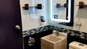 A modern bathroom with a glass-topped sink, a toilet, and a mirror with a backlit frame. - Spacious and private apartment (Oaxaca de Juárez)