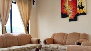 A modern living room with a sectional sofa, a coffee table, and artwork on the wall. - Spacious and private apartment (Oaxaca de Juárez)