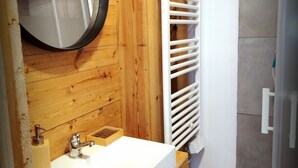 A bathroom with a wooden wall, a white sink, a mirror, and a white towel rack. - Grand loft du Moulin - 2-traveler room near Ancenis (Vair-sur-Loire)