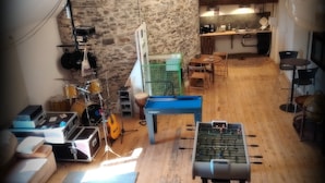 A cozy living room with a foosball table, a drum set, and a guitar. - Grand loft du Moulin - 2-traveler room near Ancenis (Vair-sur-Loire)
