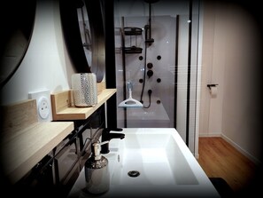 Een douche, handdoeken, zeep, toiletpapier