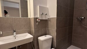 Een moderne badkamer met een wit wastafelmeubel, toilet en bad.