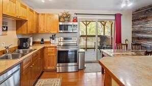 A modern kitchen with wooden cabinets, stainless steel appliances, and a large island. - Château Rouge 213 ~ Grizzly Peak Getaway (Red Lodge)