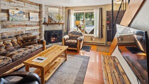 A cozy living room with a fireplace, a sofa set, and a wooden coffee table. - Château Rouge 213 ~ Grizzly Peak Getaway (Red Lodge)