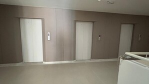 A hallway with three closed doors, each with a control panel above.