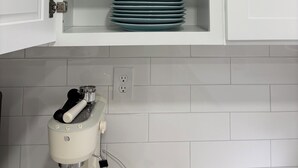 Un armari de cuina amb interior i exterior blancs, que conté bols i plats blaus apilats.