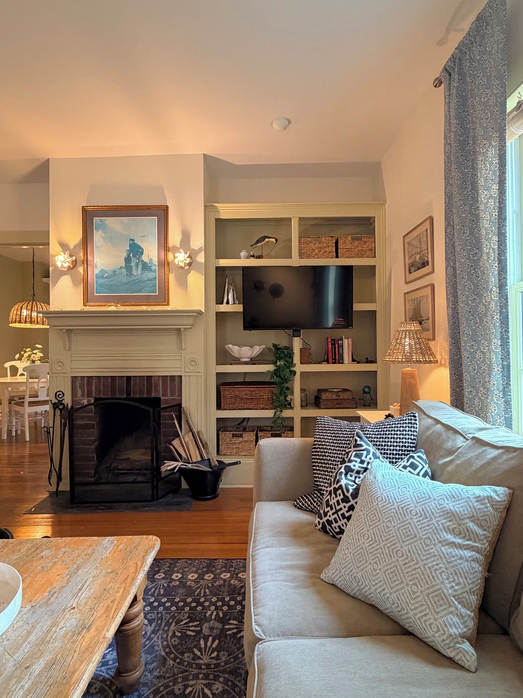 A living room with a fireplace, a sofa, a television, and a bookshelf.