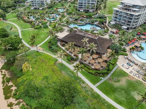 A resort with multiple swimming pools, palm trees, and a large building with a thatched roof. - Dream Vacation Studio by the Beach and Pool - Lahaina Shores 428 (Lahaina)
