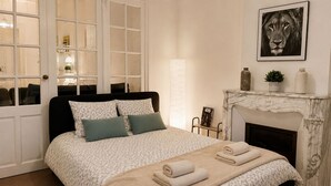 A bedroom with a bed, a fireplace, and a framed picture on the wall. - Quiet & spacious apartment - Secure bicycle garage - Fast WiFi (Saint-Quentin)