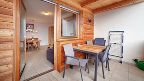 A wooden interior with a dining area, a sliding glass door, and a wall-mounted rack. - Apartment 'Schwalbennest' with Mountain View, Shared Garden and Wi-Fi (Lagundo)