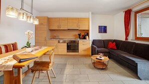 A compact living space with a kitchen, dining area, and a sofa. - Apartment 'Schwalbennest' with Mountain View, Shared Garden and Wi-Fi (Lagundo)