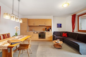 A compact living space with a kitchen, dining area, and a sofa.