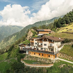 A mountain lodge with multiple balconies, a ski lift, and a view of the surrounding mountains. - Apartment 'Schwalbennest' with Mountain View, Shared Garden and Wi-Fi (Lagundo)