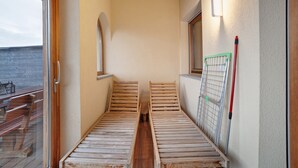A narrow corridor with two wooden benches, a window, and a wall-mounted light fixture. - Apartment 'Storchennest' with Mountain View, Shared Garden and Wi-Fi (Lagundo)