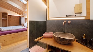 A modern bathroom with a large stone basin, wooden ceiling beams, and a skylight. - Apartment 'Bartgeier' with Mountain View, Shared Garden and Wi-Fi (Lagundo)