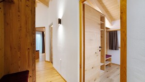 A wooden interior with a hallway leading to a room with a built-in bench and shelves. - Apartment 'Bartgeier' with Mountain View, Shared Garden and Wi-Fi (Lagundo)