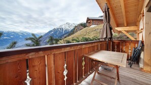 A wooden deck with a table and chairs, overlooking a mountainous landscape. - Apartment 'Bartgeier' with Mountain View, Shared Garden and Wi-Fi (Lagundo)