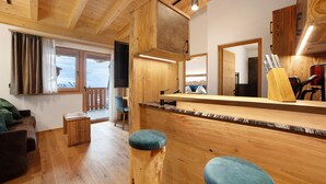 Een houten interieur met een bar, zitplaatsen en uitzicht door een raam.