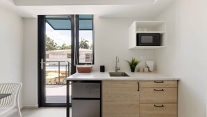 A compact kitchen with a built-in microwave, a sink, and a small countertop. - Isla Verde Ocean View | Entire 2nd Floor Suite (San Juan)