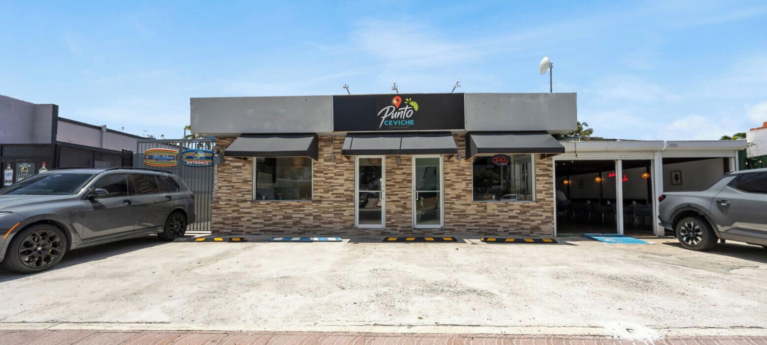 A building with a sign that reads 'Punto CeViche' and a gated entrance.