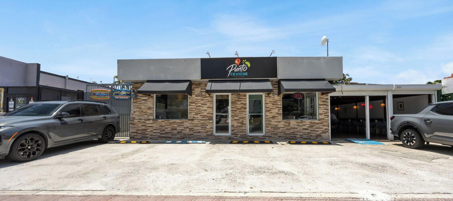 Un bâtiment avec une enseigne indiquant « Punto CeViche » et une entrée fermée par un portail.