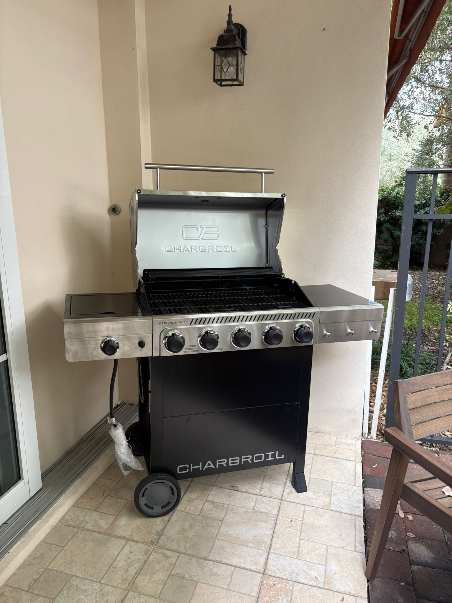 A Charbroil outdoor grill with a metal frame, a control panel with knobs, and a chimney.