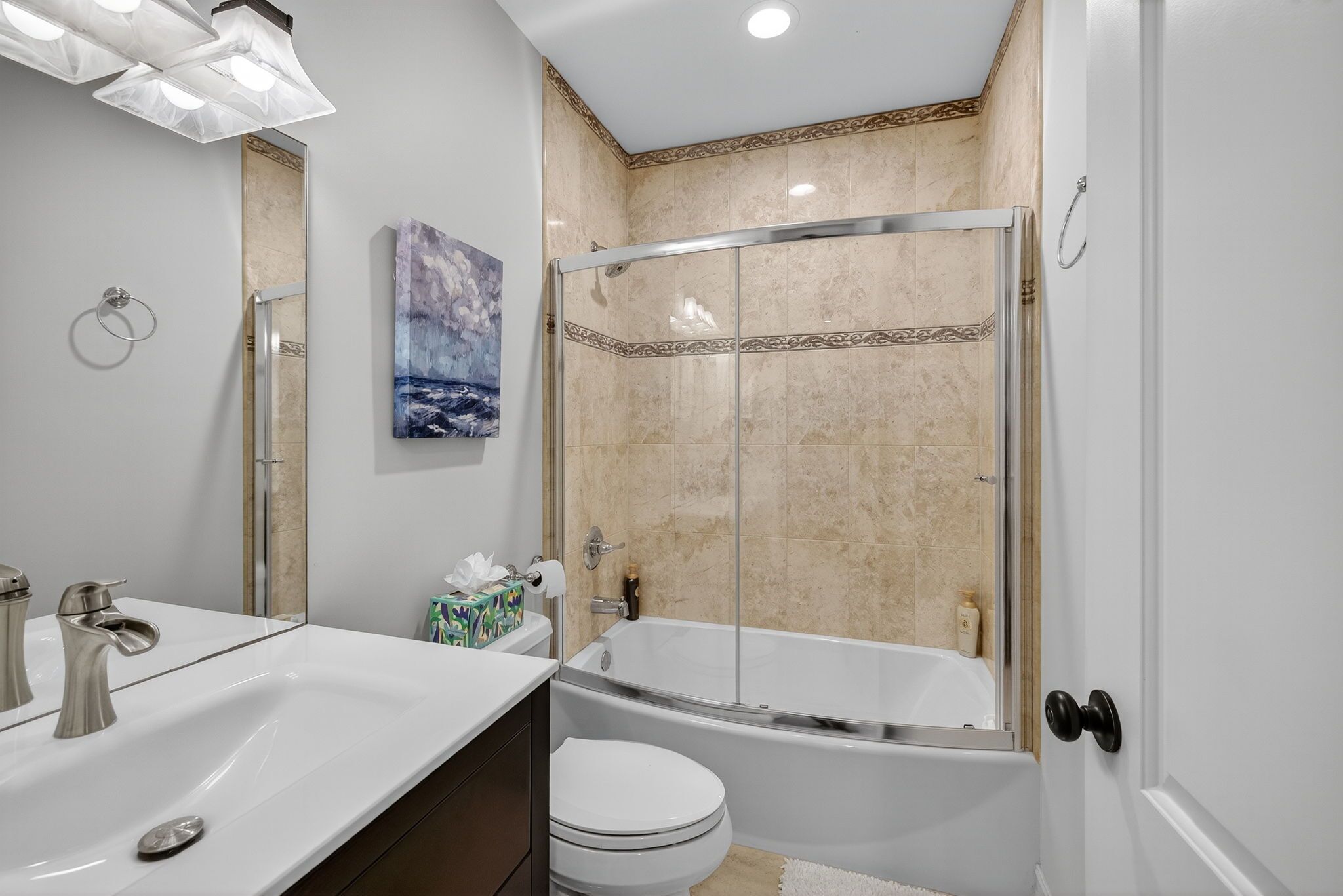 Un baño moderno con ducha envuelta en vidrio, bañera independiente y tocador con doble lavabo.