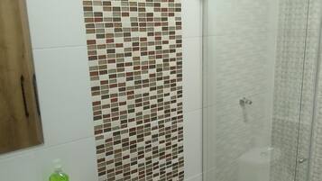 Un baño con ducha, inodoro y lavabo.