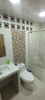 A bathroom with a shower, toilet, and sink.